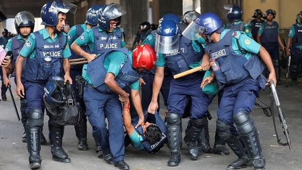 <div class="paragraphs"><p>Police carry a wounded police officer during a clash between police, pro-government supporters and protesters, after anti-quota protesters were demanding the stepping down of the Bangladeshi Prime Minister Sheikh Hasina at the Karwan Bazar area, in Dhaka, Bangladesh, August 4, 2024.</p></div>