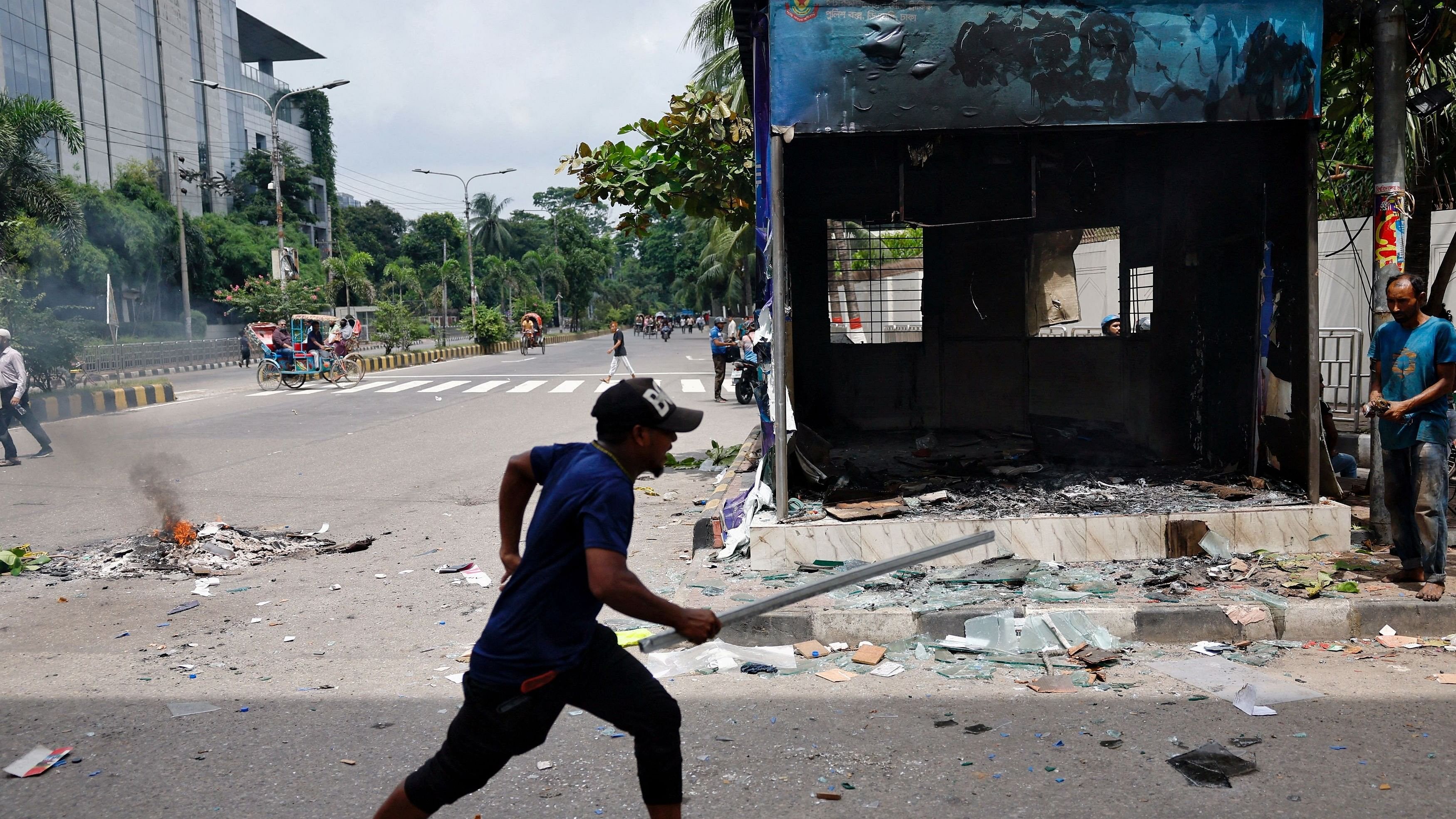 <div class="paragraphs"><p>A demonstrator runs next to a vandalised police box during a protest demanding the stepping down of Bangladeshi Prime Minister Sheikh Hasina, following quota reform protests by students, in Dhaka, Bangladesh, August 4, 2024. </p></div>