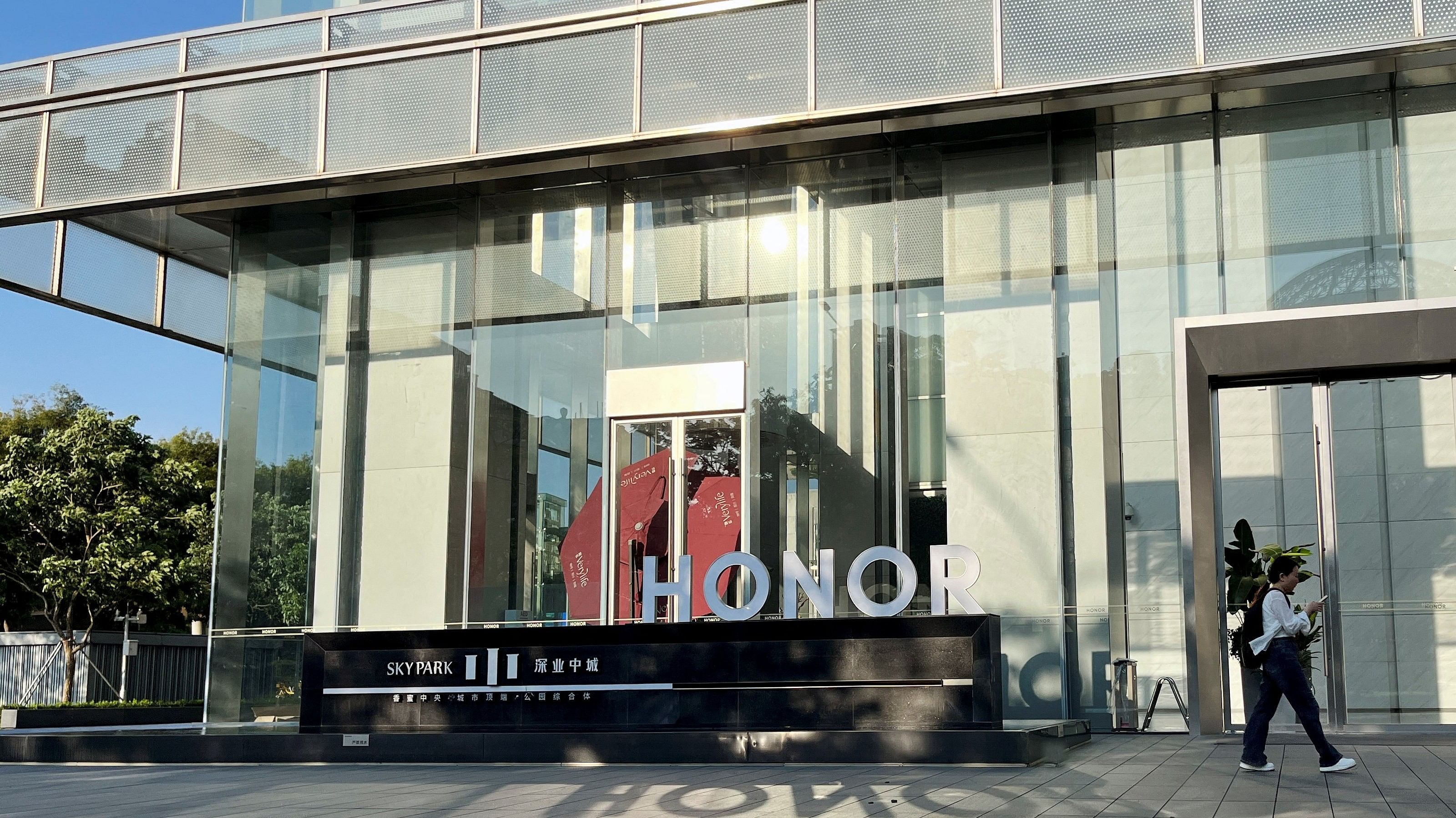 <div class="paragraphs"><p>A woman walks past an Honor sign at the handset maker's headquarters in Shenzhen, Guangdong province, China.</p></div>