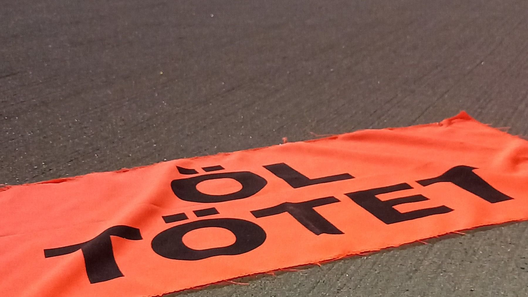 <div class="paragraphs"><p>Activists leave behind a banner on the runway of the airport</p></div>