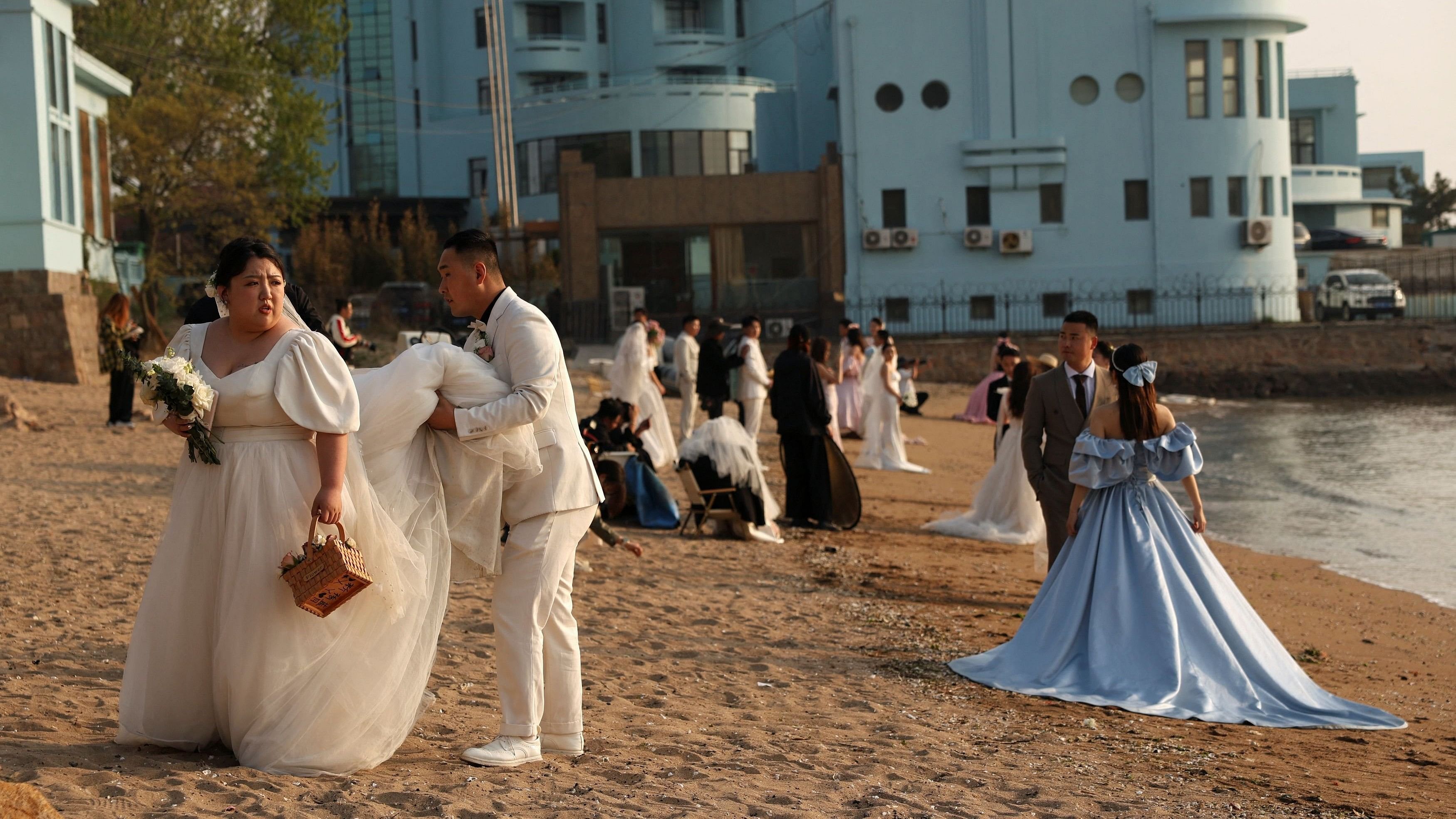 Couples take part in their pre-wedding photoshoots on a beach in Qingdao, Shandong province, China April 21, 2024. REUTERS/Florence Lo