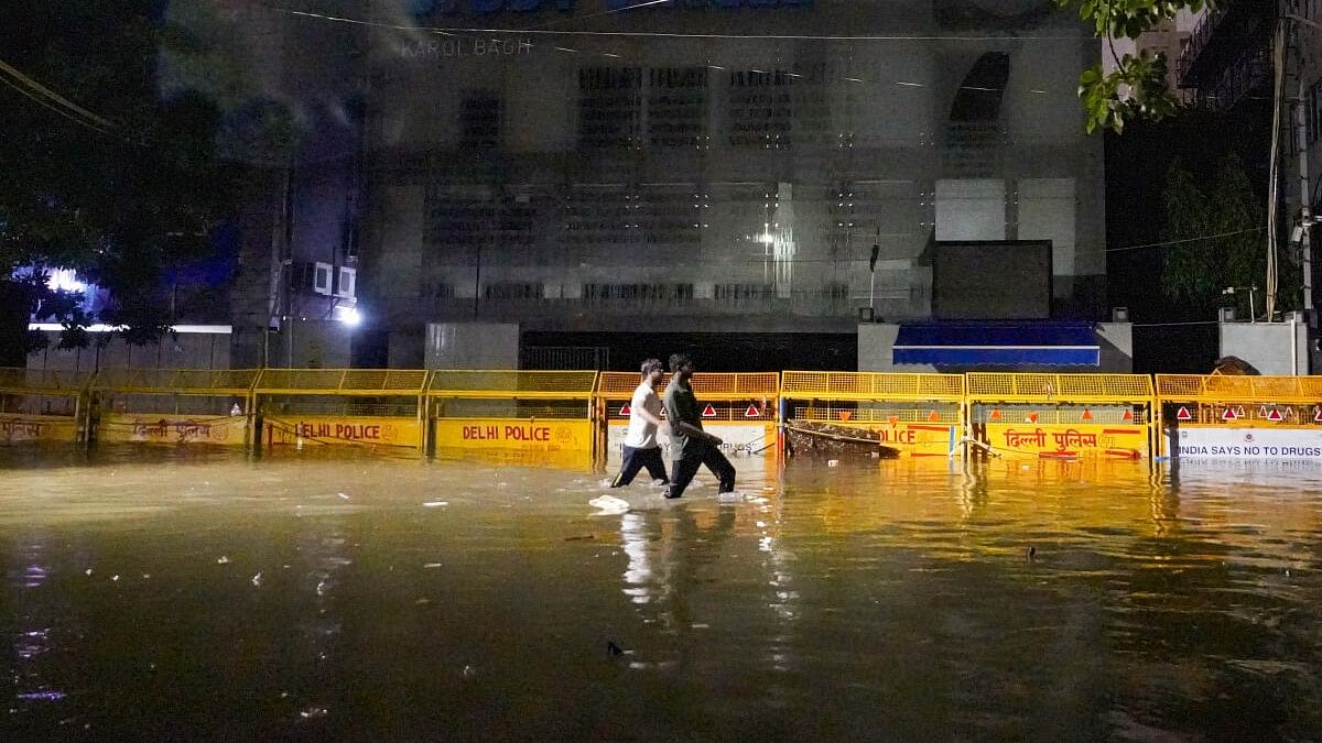 <div class="paragraphs"><p>People wade through a waterlogged area in front of Rau's IAS Study Circle at Old Rajinder Nagar, in New Delhi, Wednesday, July 31, 2024.</p></div>