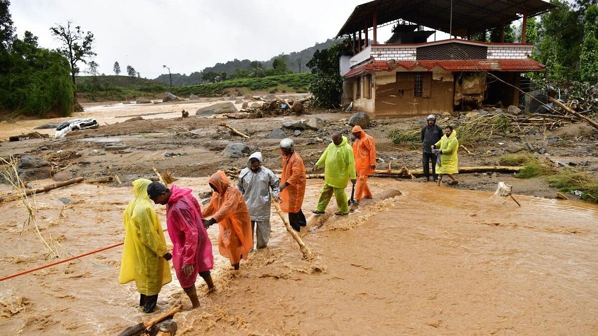 <div class="paragraphs"><p>People wade through flood water following landslides in Wayanad district.</p></div>