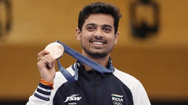 <div class="paragraphs"><p> Swapnil Kusale strikes a happy pose with his medal. </p></div>