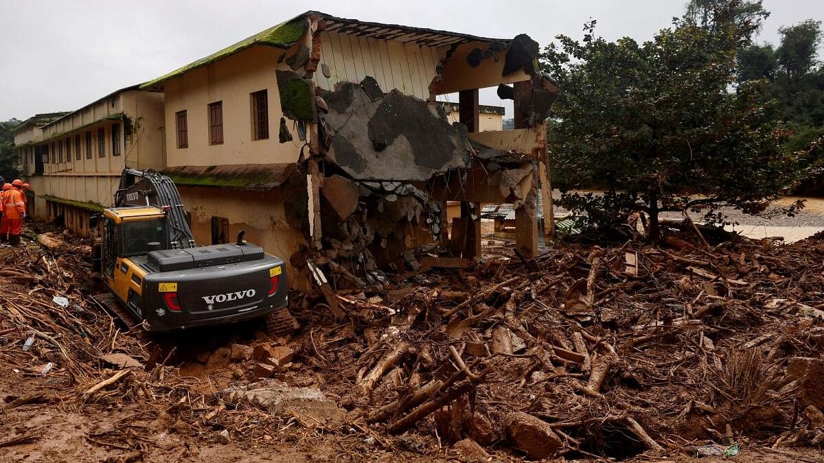 <div class="paragraphs"><p>An excavator digs next to a damaged building after several landslides hit the hills in Wayanad district.</p></div>