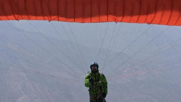 <div class="paragraphs"><p>A paragliding pilot prepares to fly in the 2024 Paragliding Pre World Cup as pilots from around the world compete in various tasks, showcasing their skills and aiming to secure their position for the next World Cup, in Mecapaca near La Paz, Bolivia</p></div>