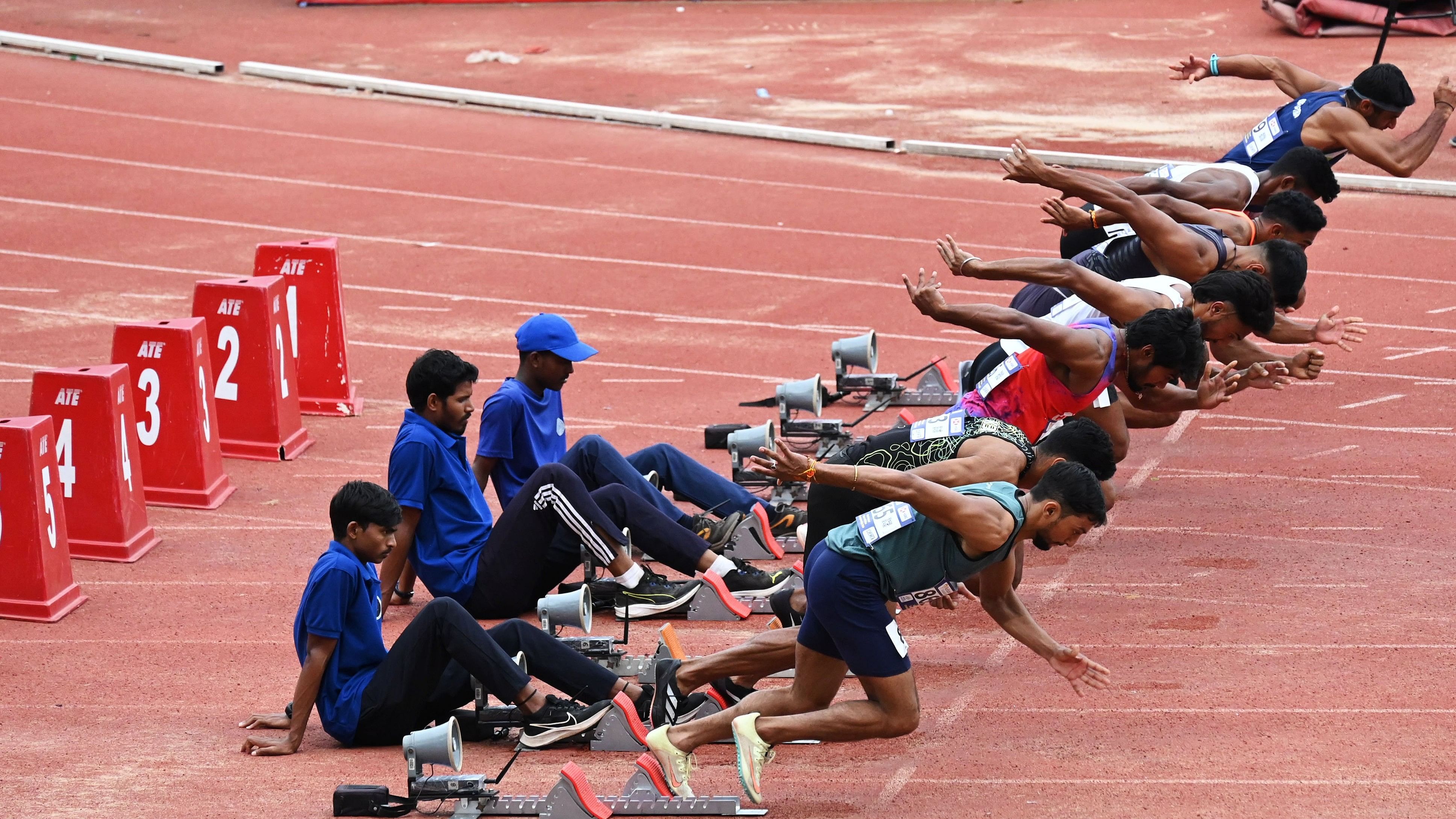 <div class="paragraphs"><p>Volunteers supporting the starting blocks at the Kanteerava Stadium.</p></div>