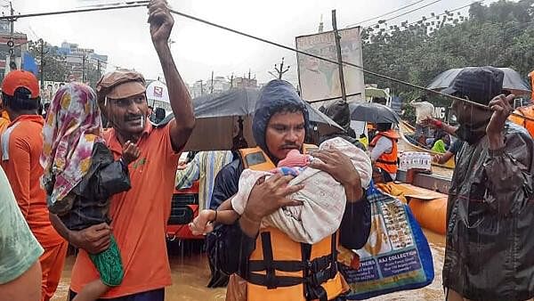 <div class="paragraphs"><p>SDRF men rescue flood-hit people, in Ajit Singh Nagar, Vijayawada.</p></div>