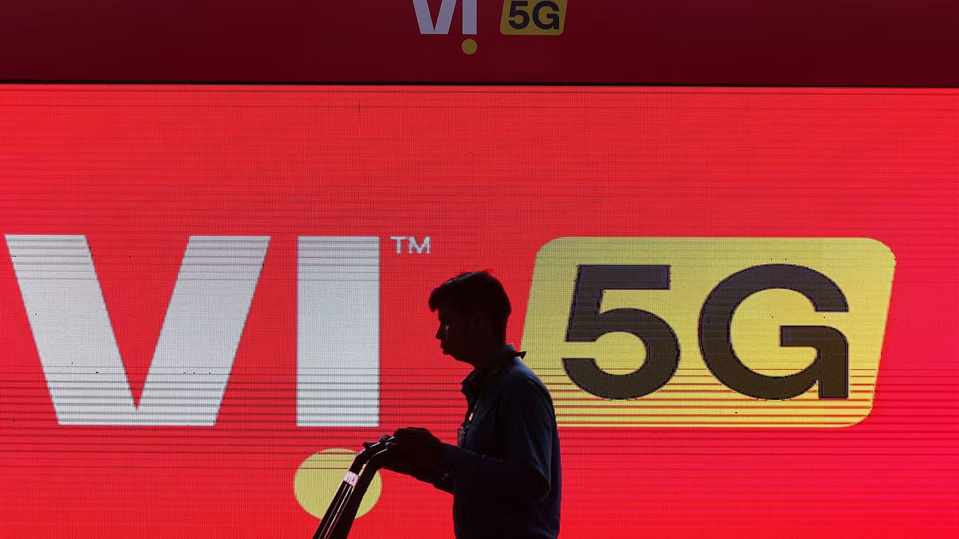 <div class="paragraphs"><p>A man walks across the LED display board showing the logo of Vodafone-Idea.</p></div>