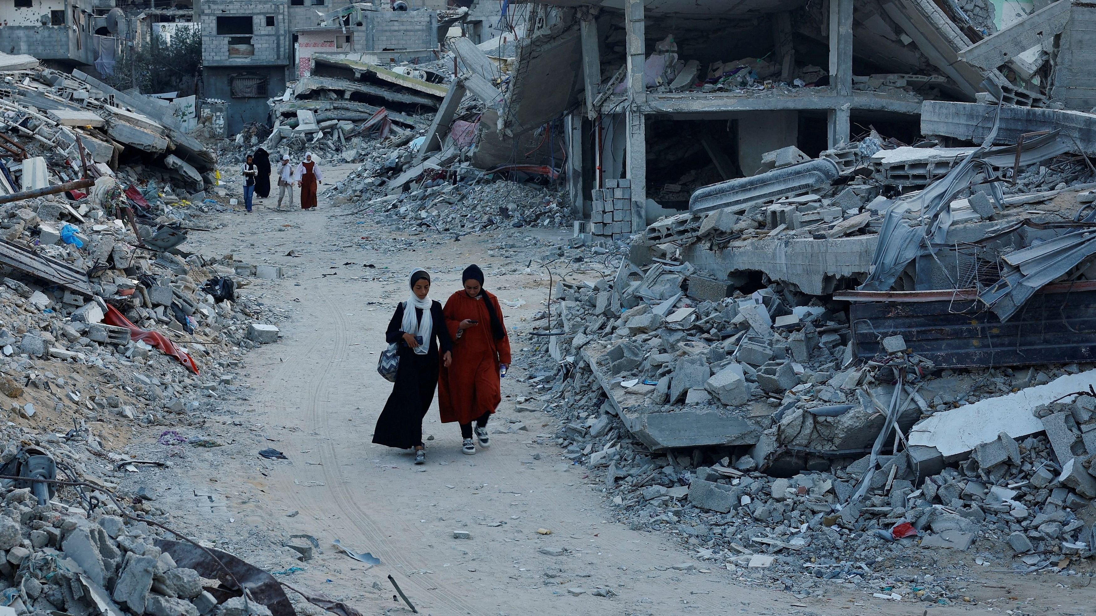 <div class="paragraphs"><p>Palestinians walk amidst the rubble of buildings destroyed after an Israeli strike, September 1, 2024.</p></div>