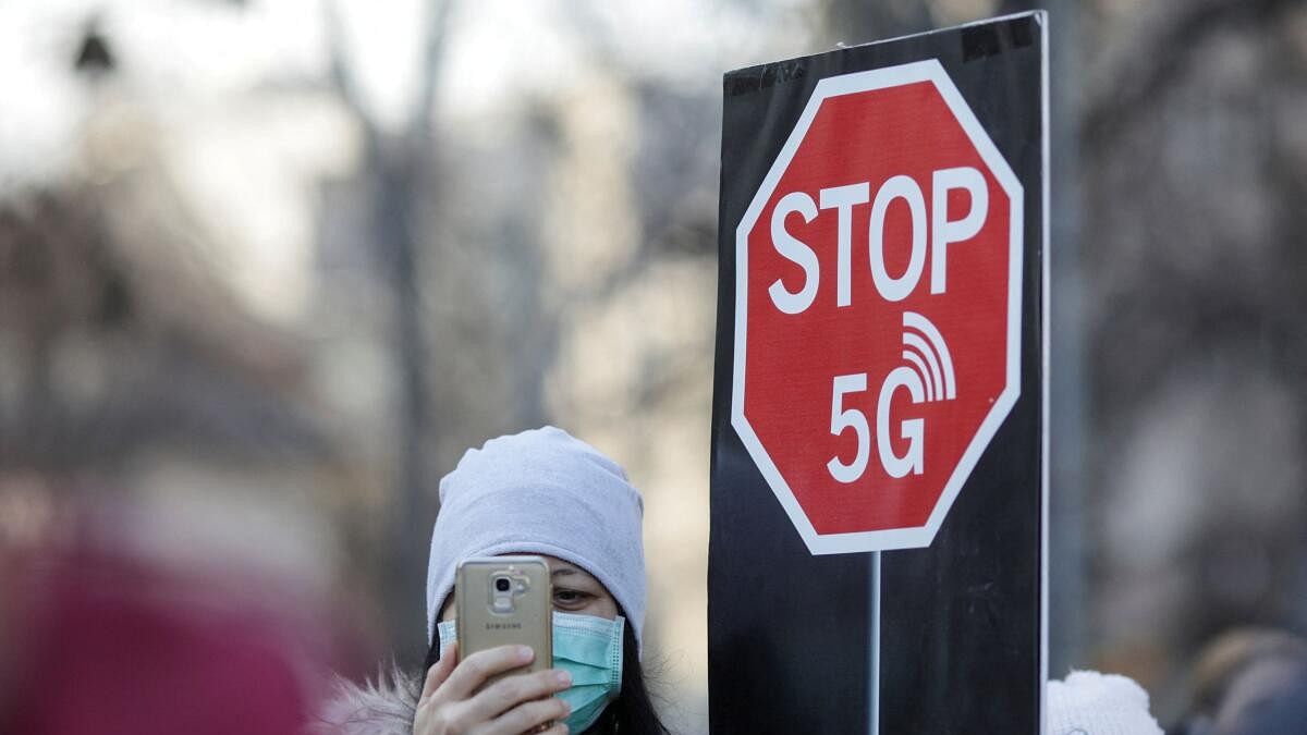 <div class="paragraphs"><p>A woman uses her mobile phone while holding a placard reading " STOP 5G" during a protest against 5G technology, in Bucharest, Romania.</p></div>