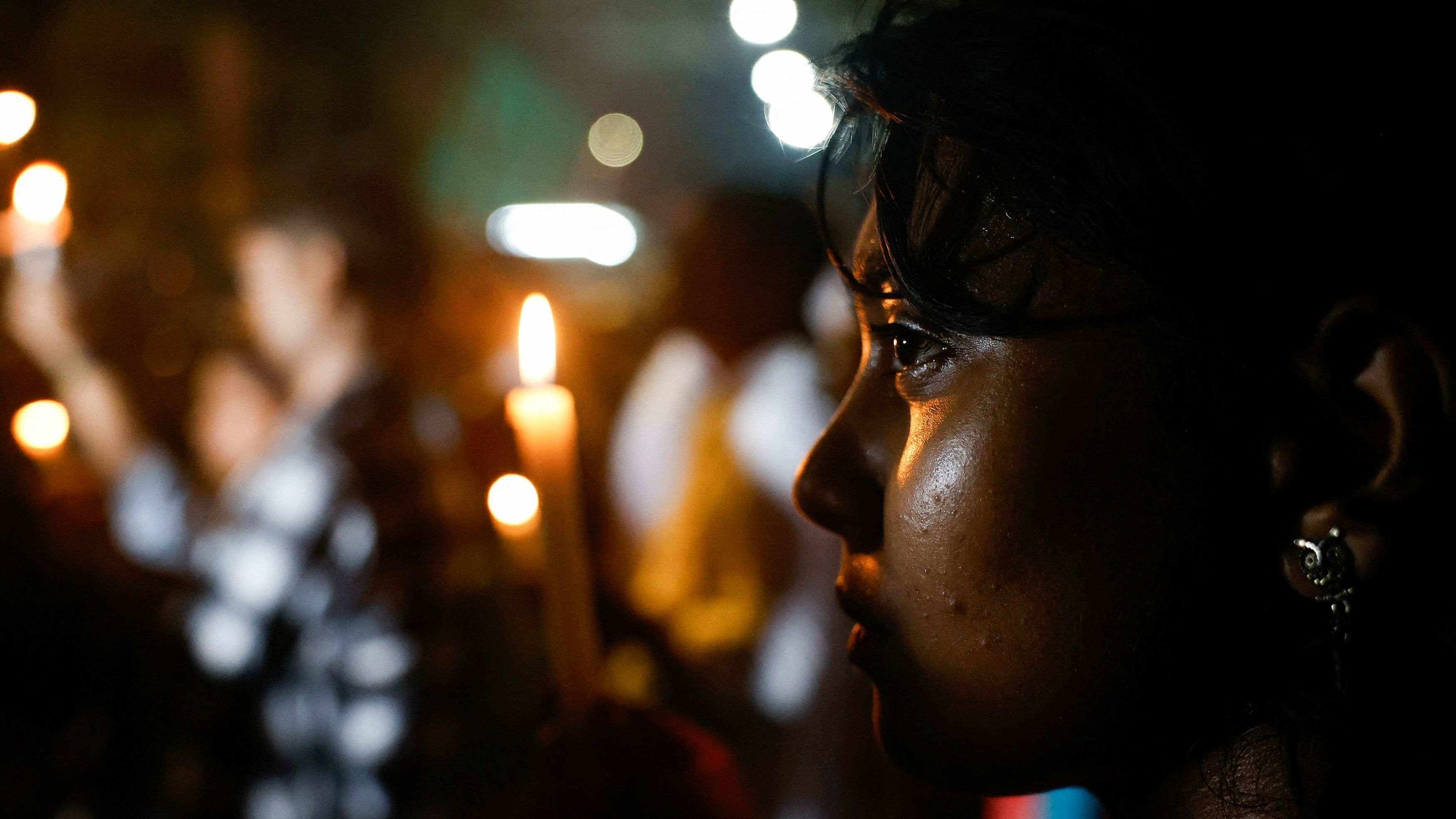 <div class="paragraphs"><p>A woman looks on as people hold candles during a doctors' protest rally demanding justice, following the rape and murder of a trainee medic at a hospital in Kolkata.</p></div>