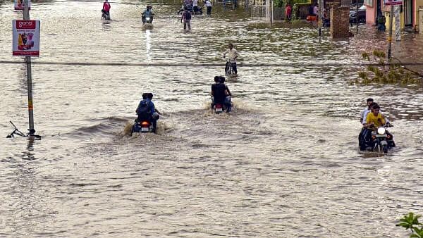 <div class="paragraphs"><p>Commuters move through a waterlogged road after rain, in Bikaner, Rajasthan.</p></div>