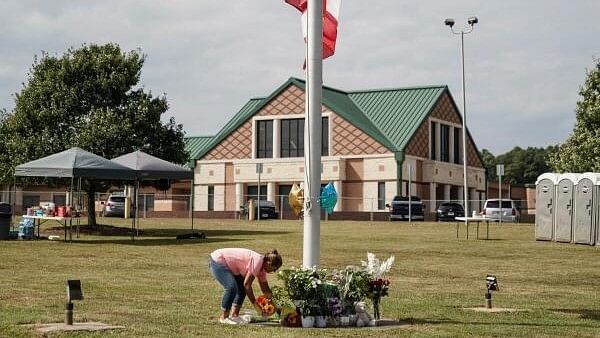 <div class="paragraphs"><p>A woman lays flowers at the base of a flagpole turned into a makeshift memorial in front of Apalachee High School the day after a fatal shooting left four dead in Winder, Georgia, US September 5, 2024. </p></div>