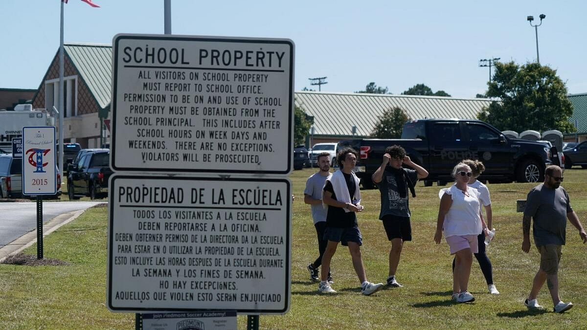 <div class="paragraphs"><p>People walk next to a sign, near the scene of a shooting at Apalachee High School in Winder, Georgia, US September 4, 2024. </p></div>