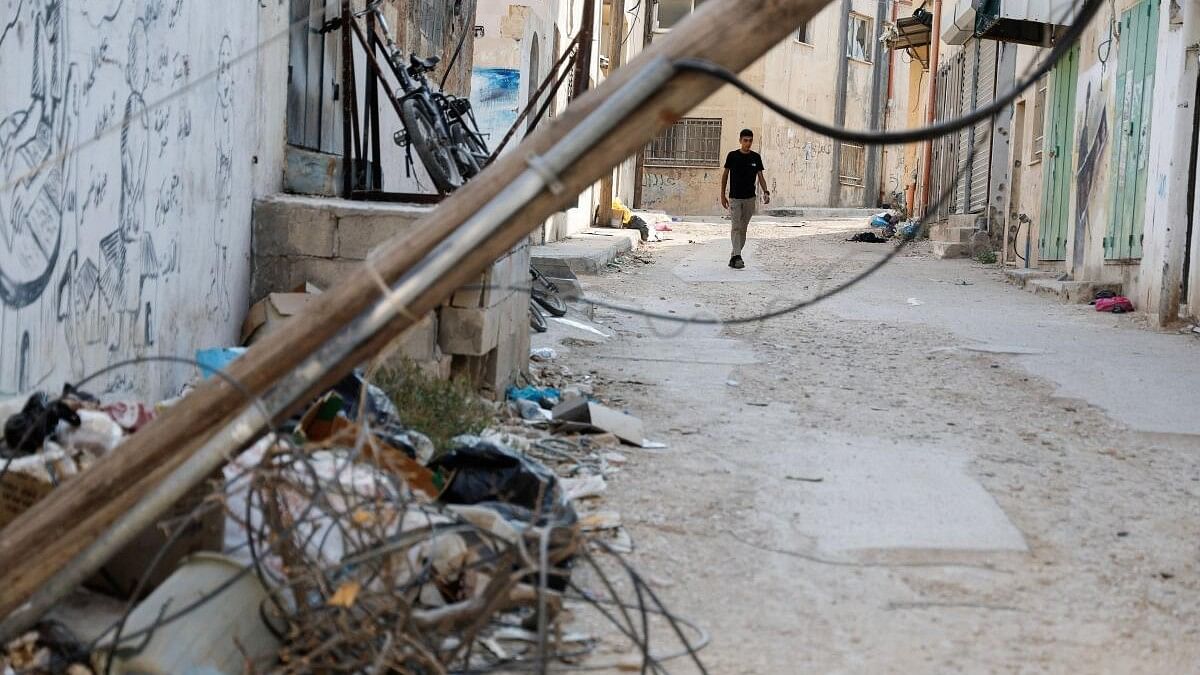 <div class="paragraphs"><p>A Palestinian walks along a road, following a several day long Israeli-raid, in Jenin camp, in the Israeli-occupied West Bank.</p></div>