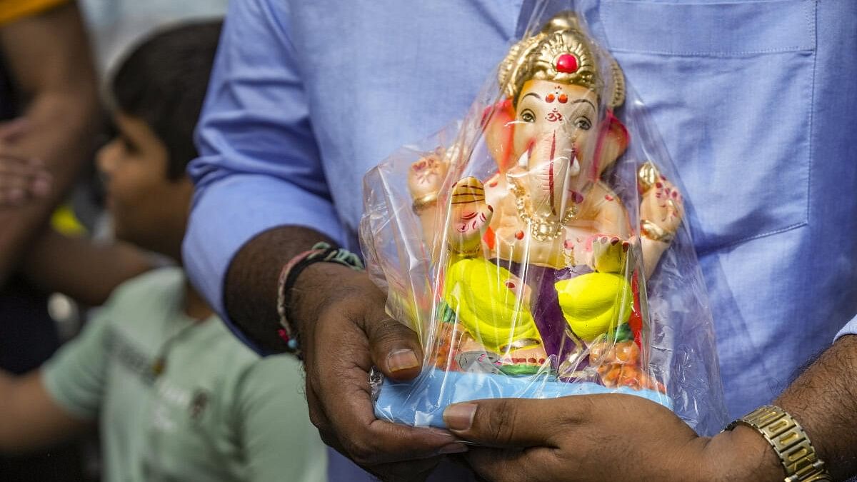 <div class="paragraphs"><p>A devotee carries an idol of Lord Ganesha on the first day of the ten-day-long Ganesh Chaturthi festival.</p></div>