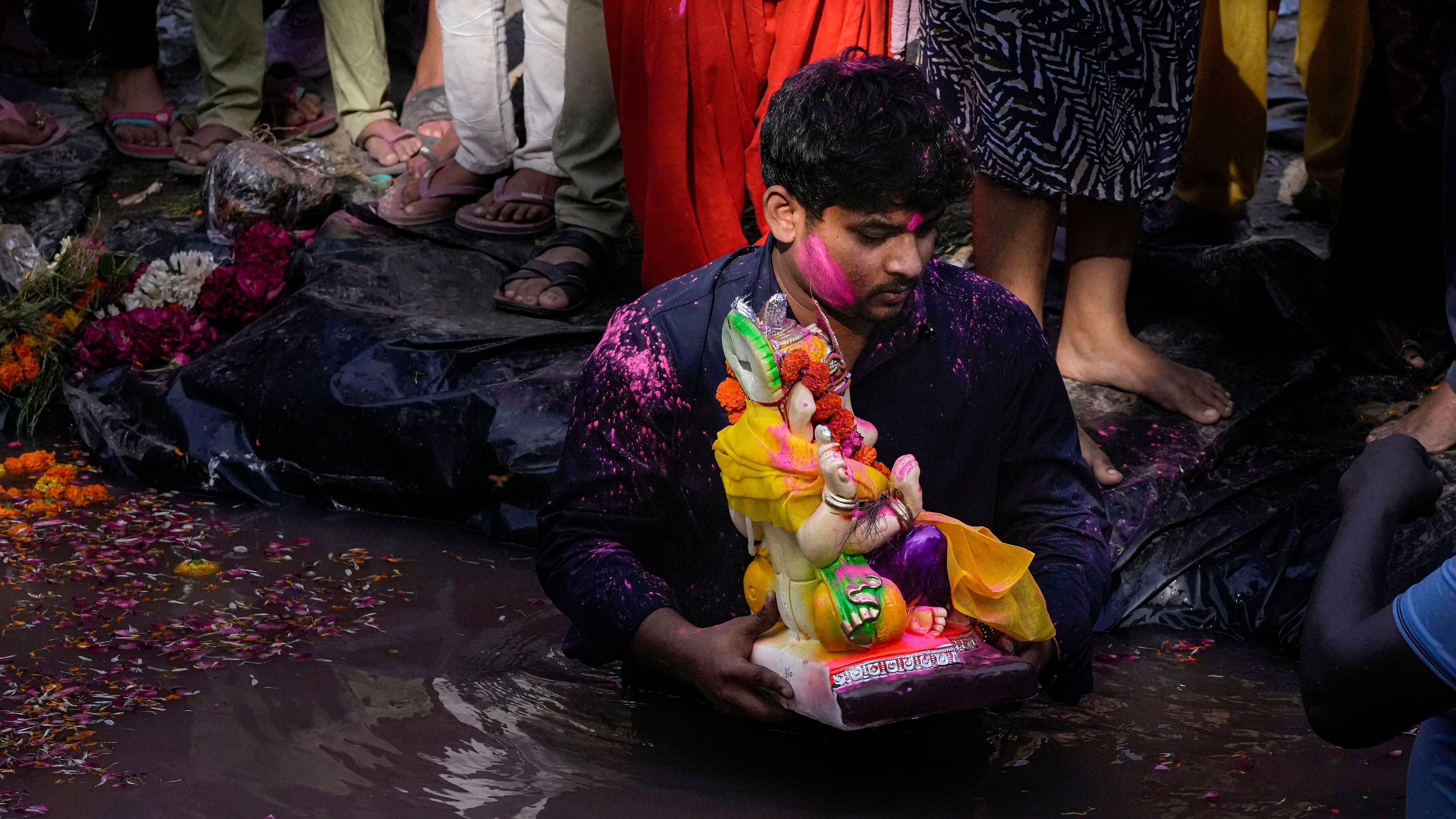 <div class="paragraphs"><p>Devotees immerse an idol of Lord Ganesha in a makeshift pool during Ganesha Visarjan as part of the Ganesh Chaturthi festival.&nbsp;</p></div>