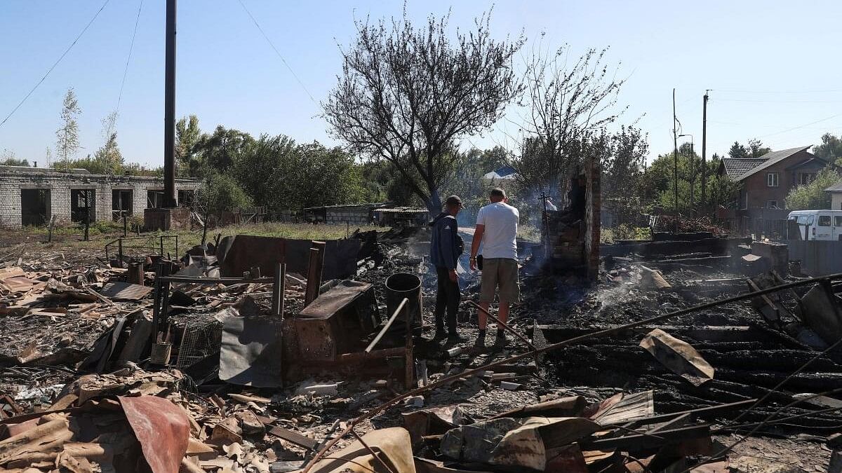 <div class="paragraphs"><p>Residents stand at a site of a building destroyed by a Russian military strike, amid Russia's attack on Ukraine.</p></div>