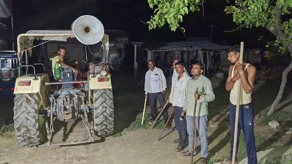 <div class="paragraphs"><p> Locals stand guard with sticks and rods to keep a vigil amid wolf attacks, at Orahi village, in Bahraich district.</p></div>