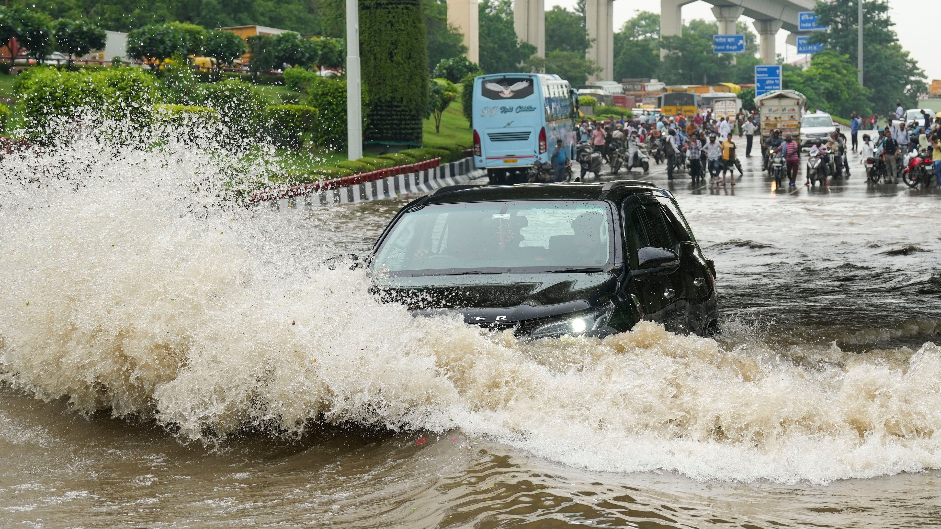 <div class="paragraphs"><p>A vehicle moves through a flooded road after heavy downpour, in New Delhi.</p></div>