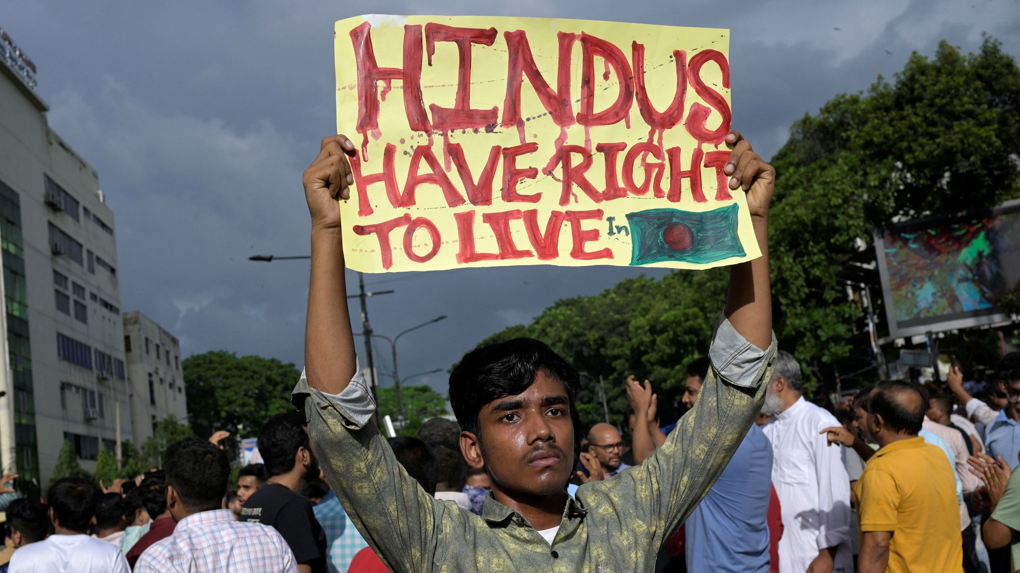 <div class="paragraphs"><p>A demonstrator displays a placard during a protest against what they say violence against Hindu communities during ongoing unrest, in Dhaka, Bangladesh, August 9, 2024.</p></div>