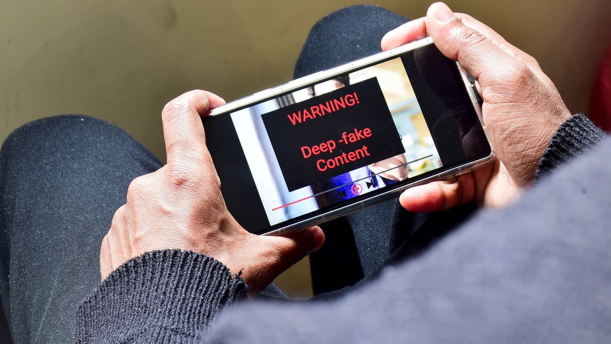 <div class="paragraphs"><p>Representative image showing a person looking at content labelled 'deep fake' on a mobile device</p></div>