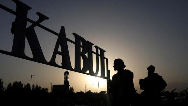 <div class="paragraphs"><p>Taliban soldiers stand in front of a sign at the international airport in Kabul</p></div>