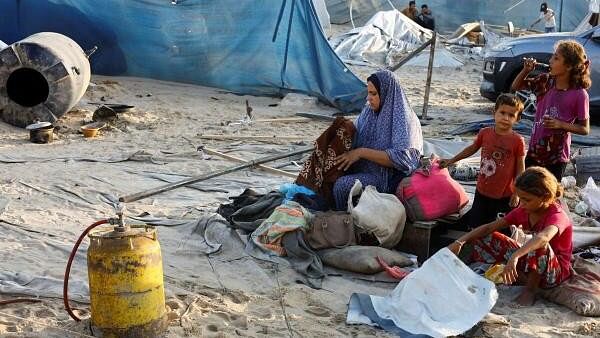 <div class="paragraphs"><p>A Palestinian woman goes through belongings next to children at the site following Israeli strikes on a tent camp sheltering displaced people, amid the Israel-Hamas conflict, at the Al-Mawasi area in Khan Younis, in the southern Gaza Strip, September 10, 2024. </p></div>