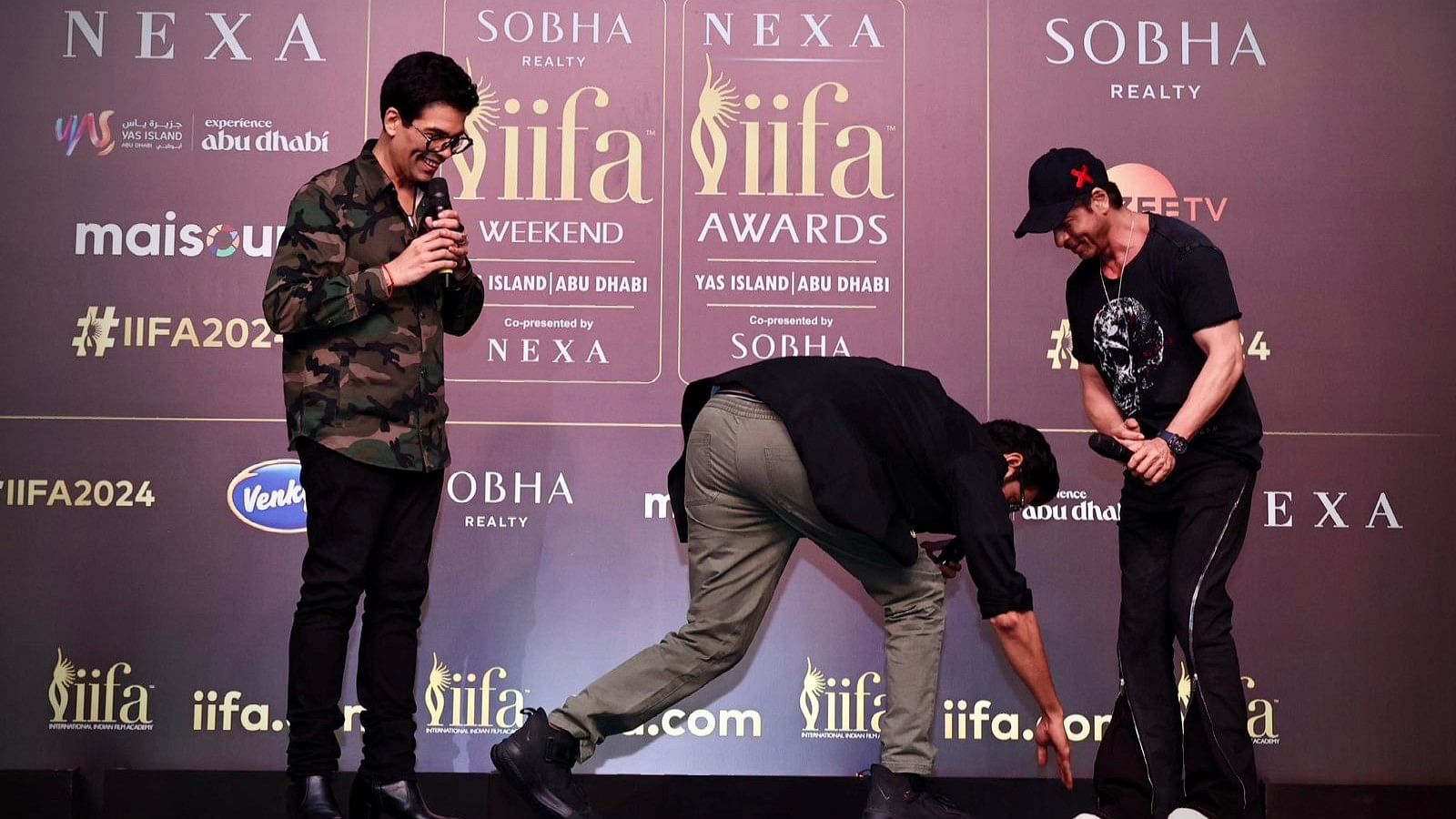 <div class="paragraphs"><p>Rana Daggubati touches Shah Rukh Khan's feet as Karan Johar looks on during the IIFA 2024 press conference in Mumbai.</p></div>