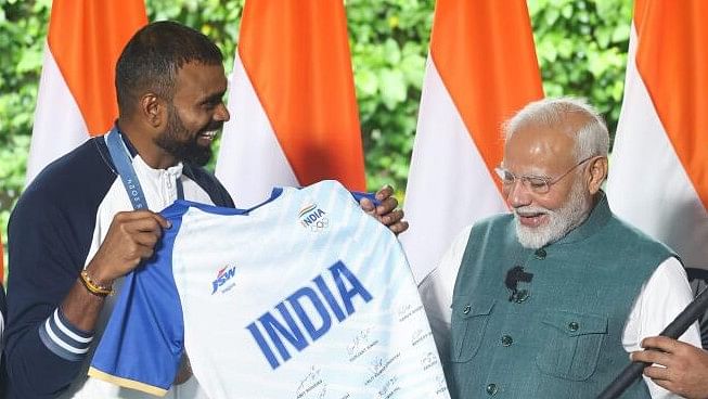 <div class="paragraphs"><p>Prime Minister Narendra Modi being presented a jersey by bronze medallist and former men's hockey team keeper PR Sreejesh during his interaction with the Indian contingent for Paris Olympics, in New Delhi.</p></div>