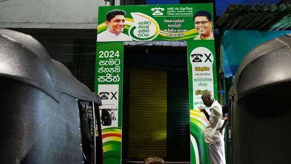 <div class="paragraphs"><p>A man drinks tea as he stands in front of the Samagi Jana Balawegaya (SJB) party presidential candidate Sajith Premadasa election campaign office in Colombo, Sri Lanka.</p></div>