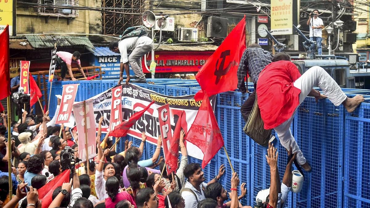 <div class="paragraphs"><p>Protestors climb makeshift barricades put up by the police against the alleged rape and murder of a medic at RG Kar Hospital, in Kolkata.&nbsp;</p></div>