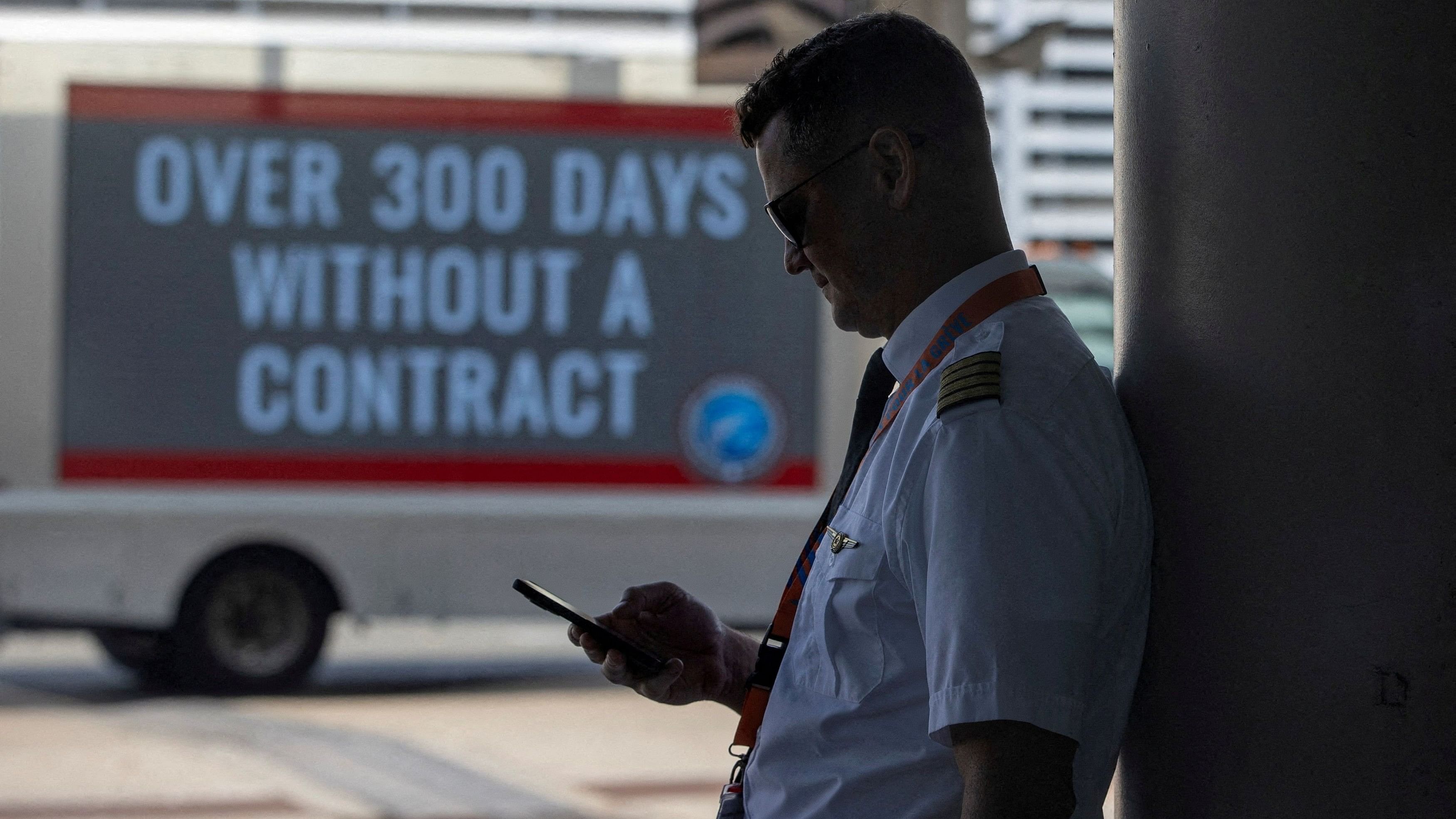 <div class="paragraphs"><p>A person holds a mobile phone as Air Canada pilots represented by the Air Line Pilots Association, Int’l, who voted to authorise a strike, hold an informational picket at Toronto Pearson International Airport in Mississauga, Ontario, Canada.</p></div>