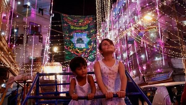 <div class="paragraphs"><p>Siblings ride on a swing as they visit an illuminated street ahead of Eid-e-Milad-ul-Nabi, the birth anniversary of Prophet Mohammad, in Karachi, Pakistan</p></div>