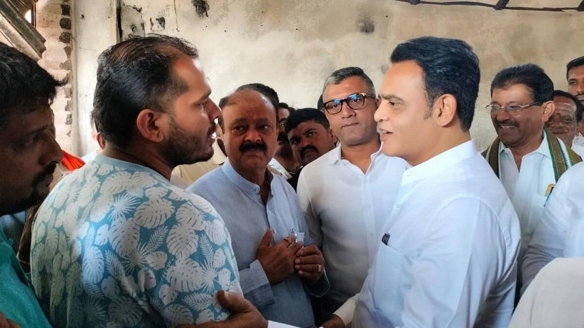 <div class="paragraphs"><p>Former minister C N Ashwath Narayan Gowda speaks to Bheema, whose shop was vandalised in the riot, in Nagamanagala. <br></p></div>