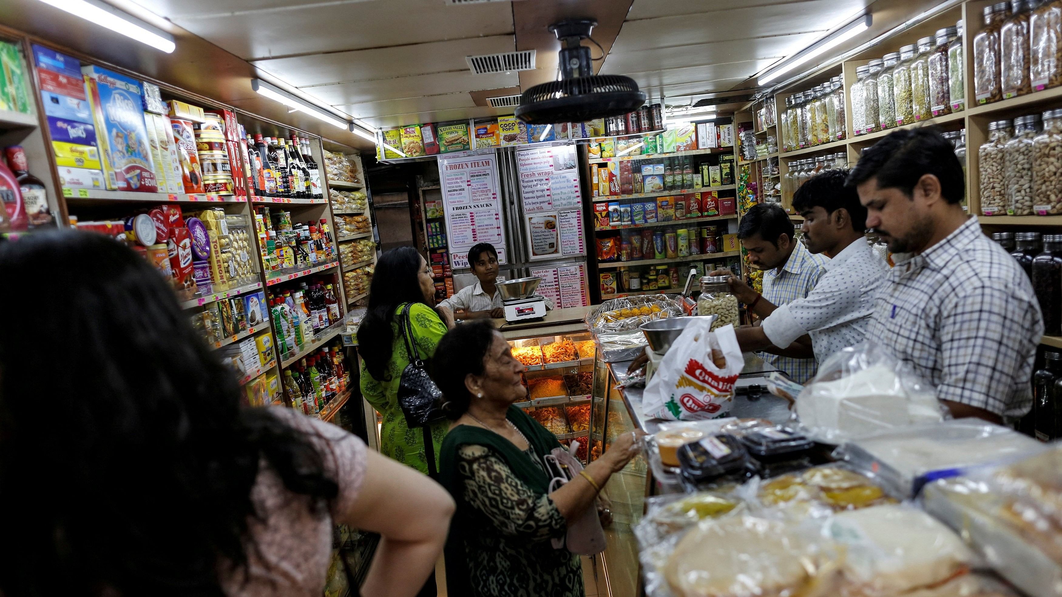 <div class="paragraphs"><p>FILE PHOTO: People shop inside a grocery store at a residential area in Mumbai, India</p></div>