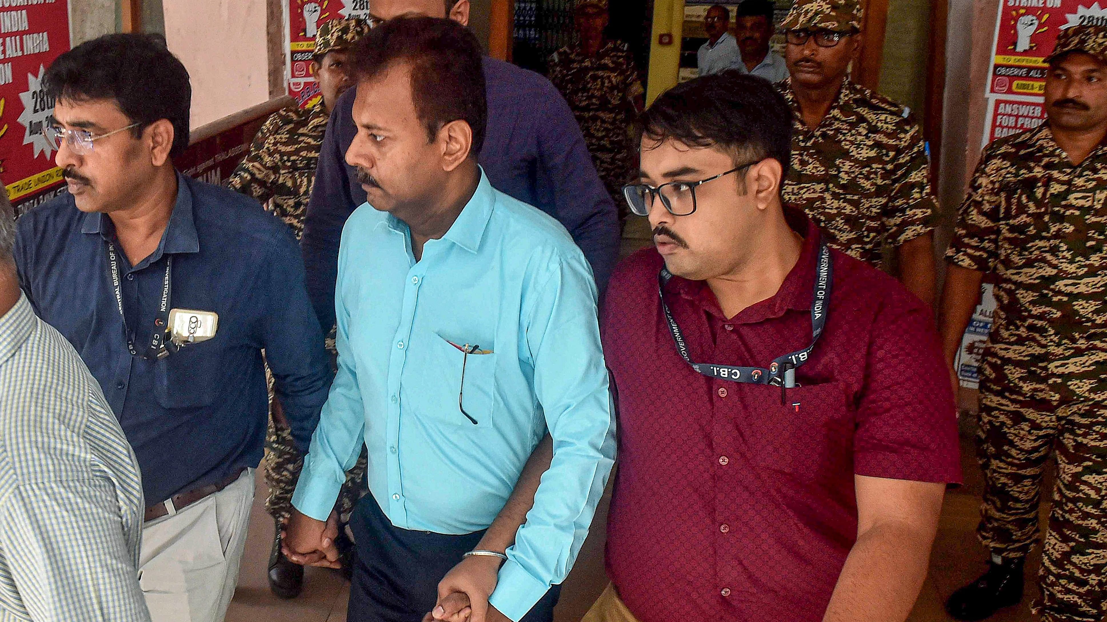 <div class="paragraphs"><p>CBI officials take Ex-RG Kar College principal Sandip Ghosh, in blue shirt, to the court, in Kolkata, Tuesday.</p></div>