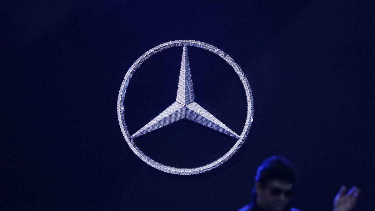 <div class="paragraphs"><p>A man walks past the logo of Mercedes-Benz.</p></div>