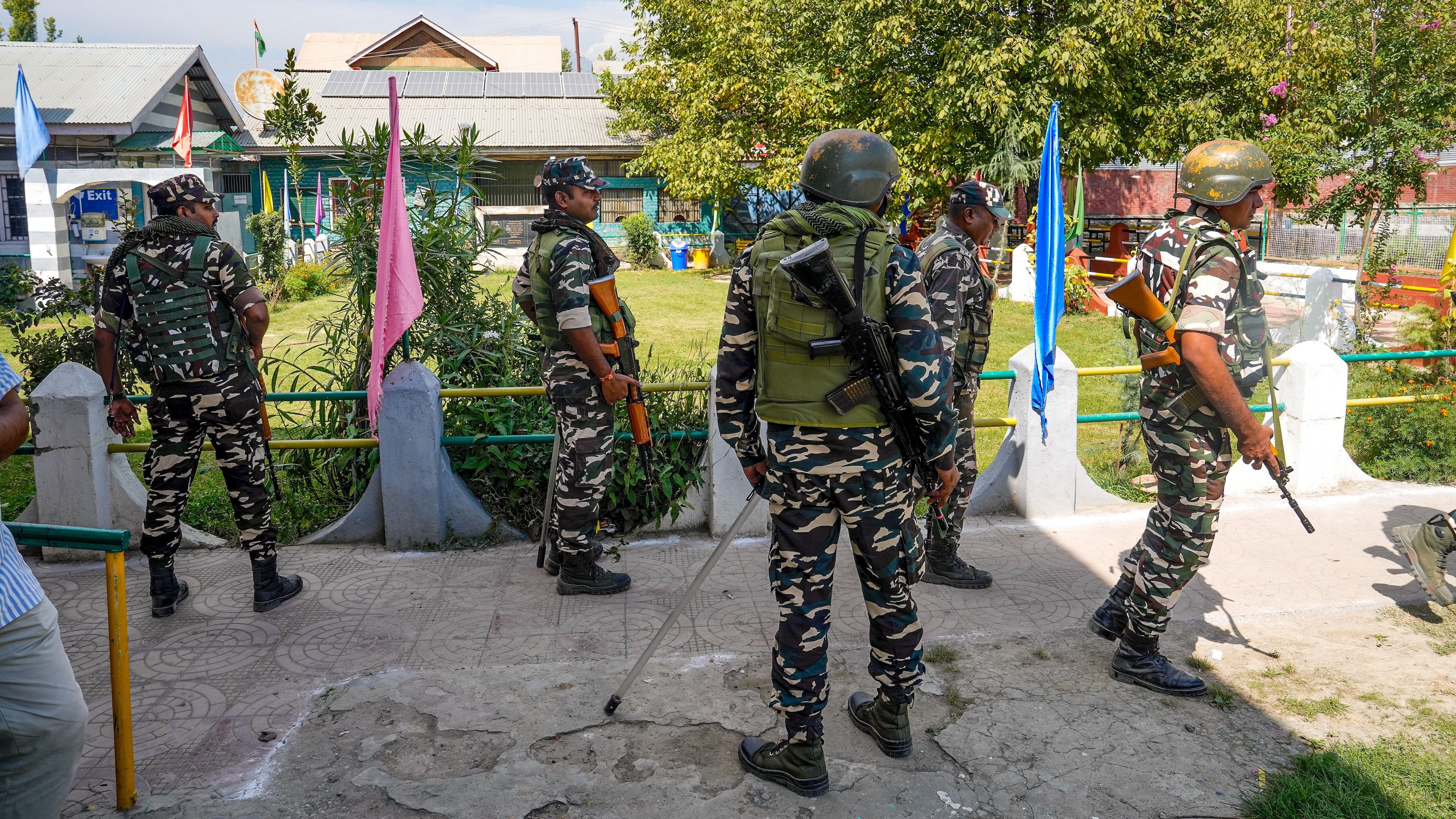 <div class="paragraphs"><p>Security personnel stand guard at a polling station ahead of the 1st phase of Jammu and Kashmir Assembly elections, at Pampore area in Pulwama district of South Kashmir, Tuesday.</p></div>