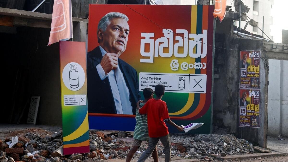 <div class="paragraphs"><p>Boys walk past a poster of Sri Lanka's president Ranil Wickremesinghe, near a his election campaign office, ahead of the upcoming presidential election, scheduled for September 21, in Colombo.</p></div>