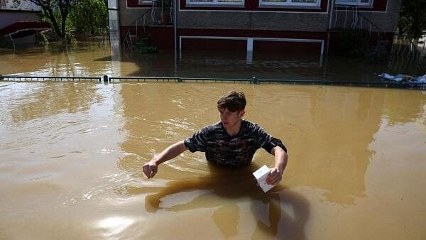 <div class="paragraphs"><p>A person walks through floodwater, in an area flooded by the Nysa Klodzka river, following heavy rainfalls, in Lewin Brzeski, Poland.</p></div>