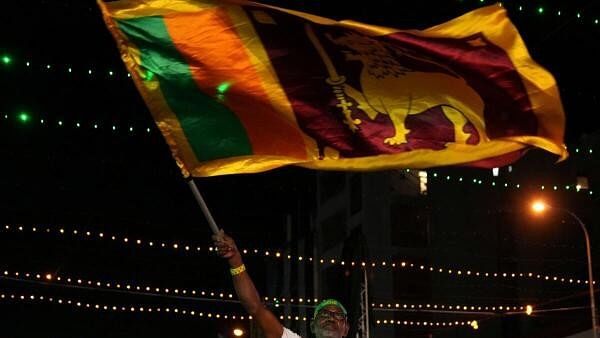 <div class="paragraphs"><p>A supporter waves Sri Lanka's national flag during an election campaign rally for Sajith Premadasa, leader of the Samagi Jana Balawegaya (SJB) party, ahead of the presidential election, in Colombo.</p></div>