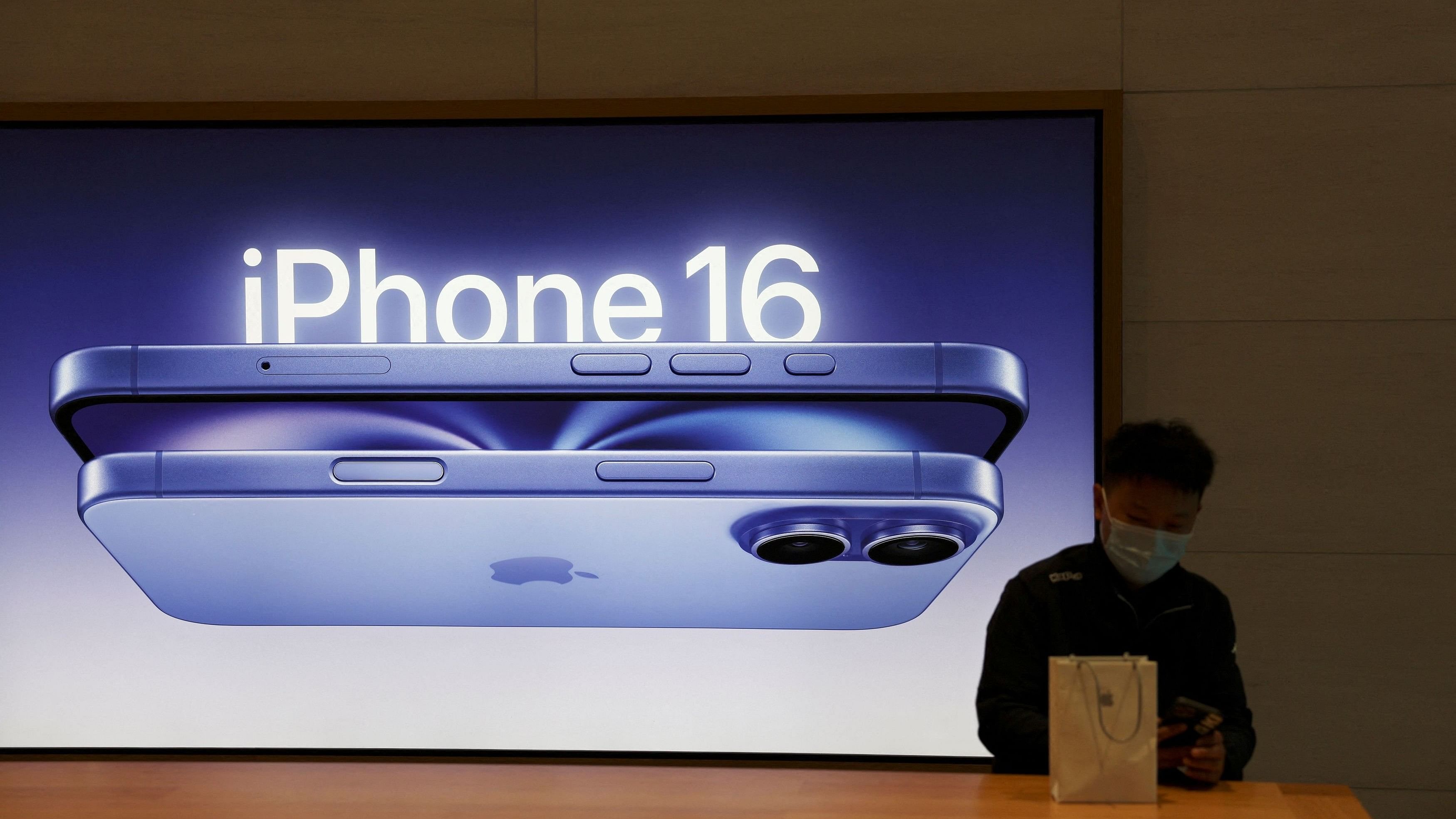 <div class="paragraphs"><p>A man sits next to an iPhone 16 advertisement as the new iPhone 16 series smartphones go on sale at an Apple store in Beijing, China.</p></div>