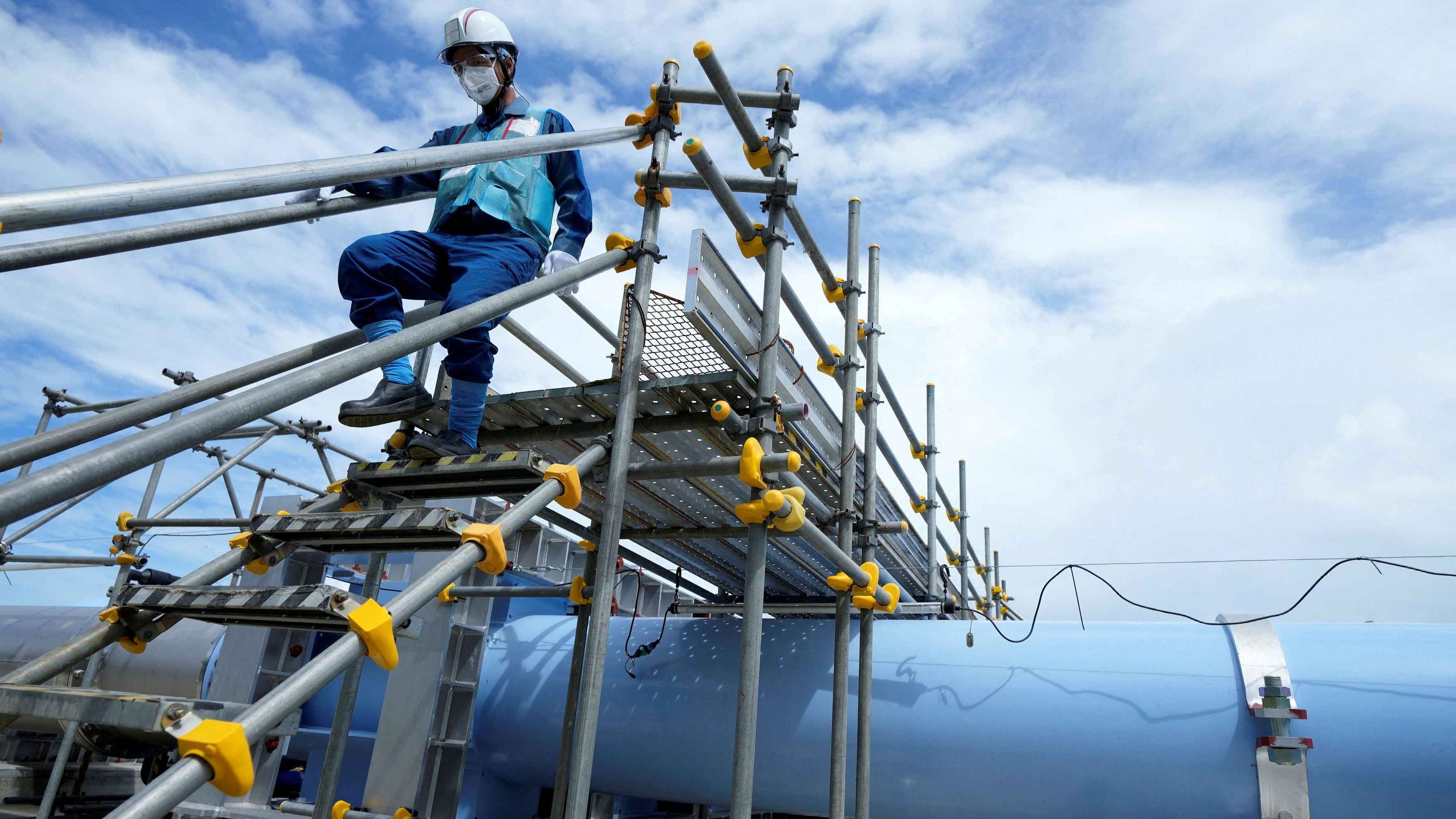 <div class="paragraphs"><p>A member of staff walks near a blue pipeline to transport seawater, part of the facility for releasing treated radioactive water to sea from the Fukushima Daiichi nuclear power plant, operated by Tokyo Electric Power Company Holdings, also known as TEPCO, during a treated water dilution and discharge facility tour for foreign media, in Futaba town, northeastern Japan     </p></div>