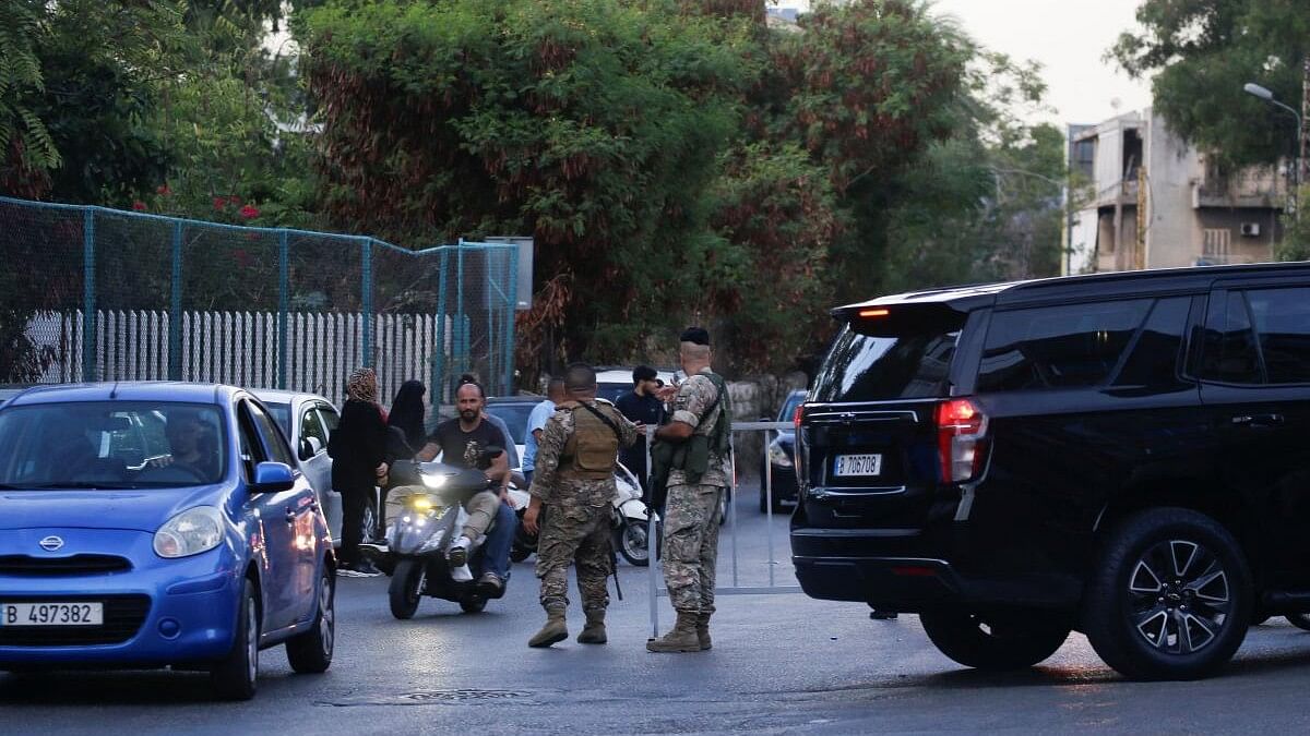 <div class="paragraphs"><p>Members of the military stand outside a hospital, after an Israeli strike in the southern suburbs of Beirut.</p></div>