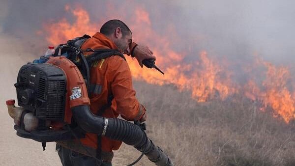 <div class="paragraphs"><p>A man reacts as he attempts to extinguish flames following a rocket attack from Lebanon, amid cross-border hostilities between Hezbollah and Israel, in the Israeli-occupied Golan Heights September 20, 2024.</p></div>