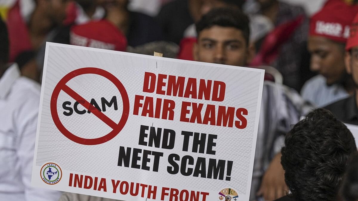 <div class="paragraphs"><p>An agitator holds a placard during a protest  over the alleged irregularities in NEET 2024 results.&nbsp;</p></div>