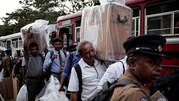 <div class="paragraphs"><p>Election officials carrying ballot boxes arrive at a counting center, after voting ended for the presidential election, in Jaffna, Sri Lanka September 21, 2024.</p></div>