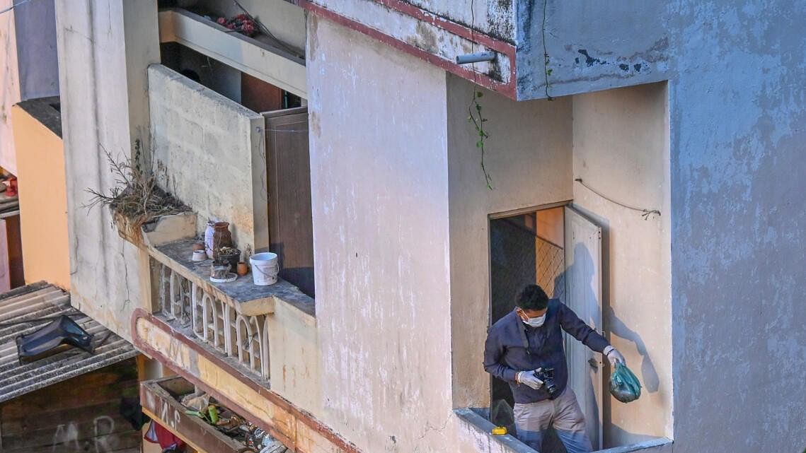 <div class="paragraphs"><p>Police and forensic team examine the house where the body was found.</p></div>